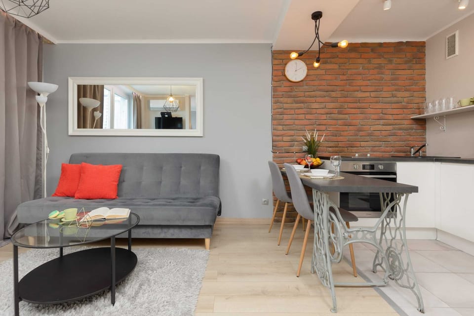 A stylish dining area with a table for four, complemented by an exposed brick wall. Modern lighting fixtures add an industrial charm.