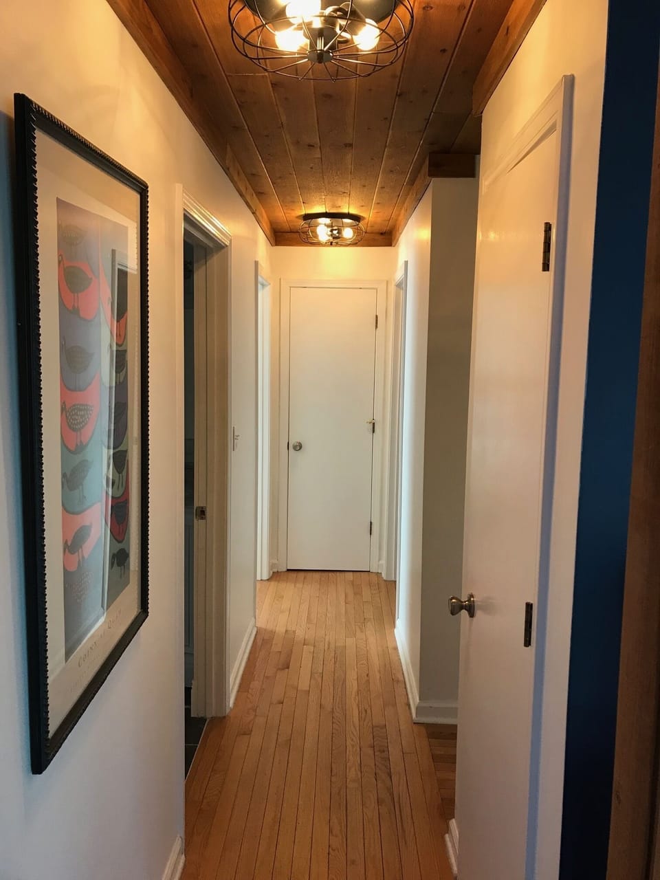 Hallway leading to full bath and 2 bedrooms