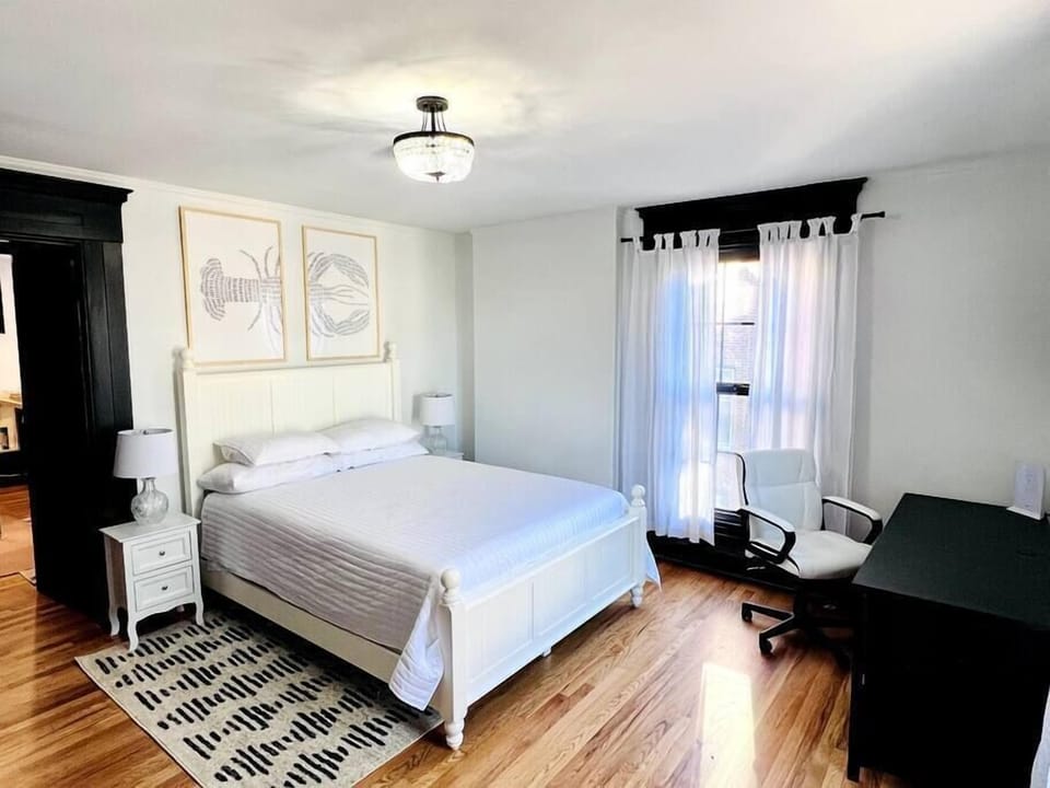 This adjacent one bedroom unit has a spacious bedroom area with a queen bed, desk, and dresser.