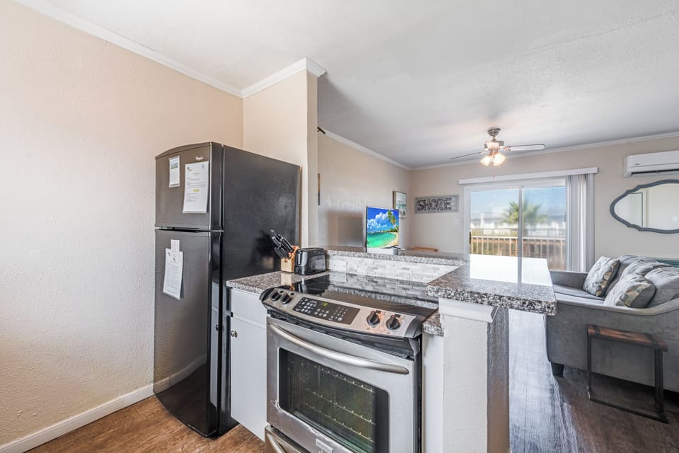 Your fully equipped kitchen features granite counters, stainless appliances, and an open layout flowing into your comfortable living space.