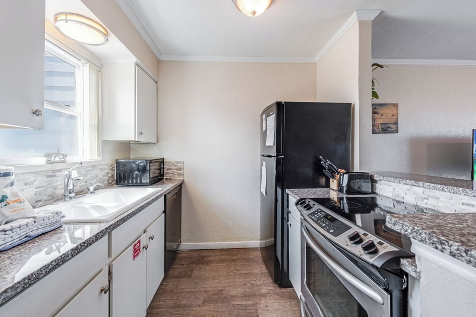 Cook your favorite meals in this bright, fully-equipped kitchen with granite counters and modern appliances.
