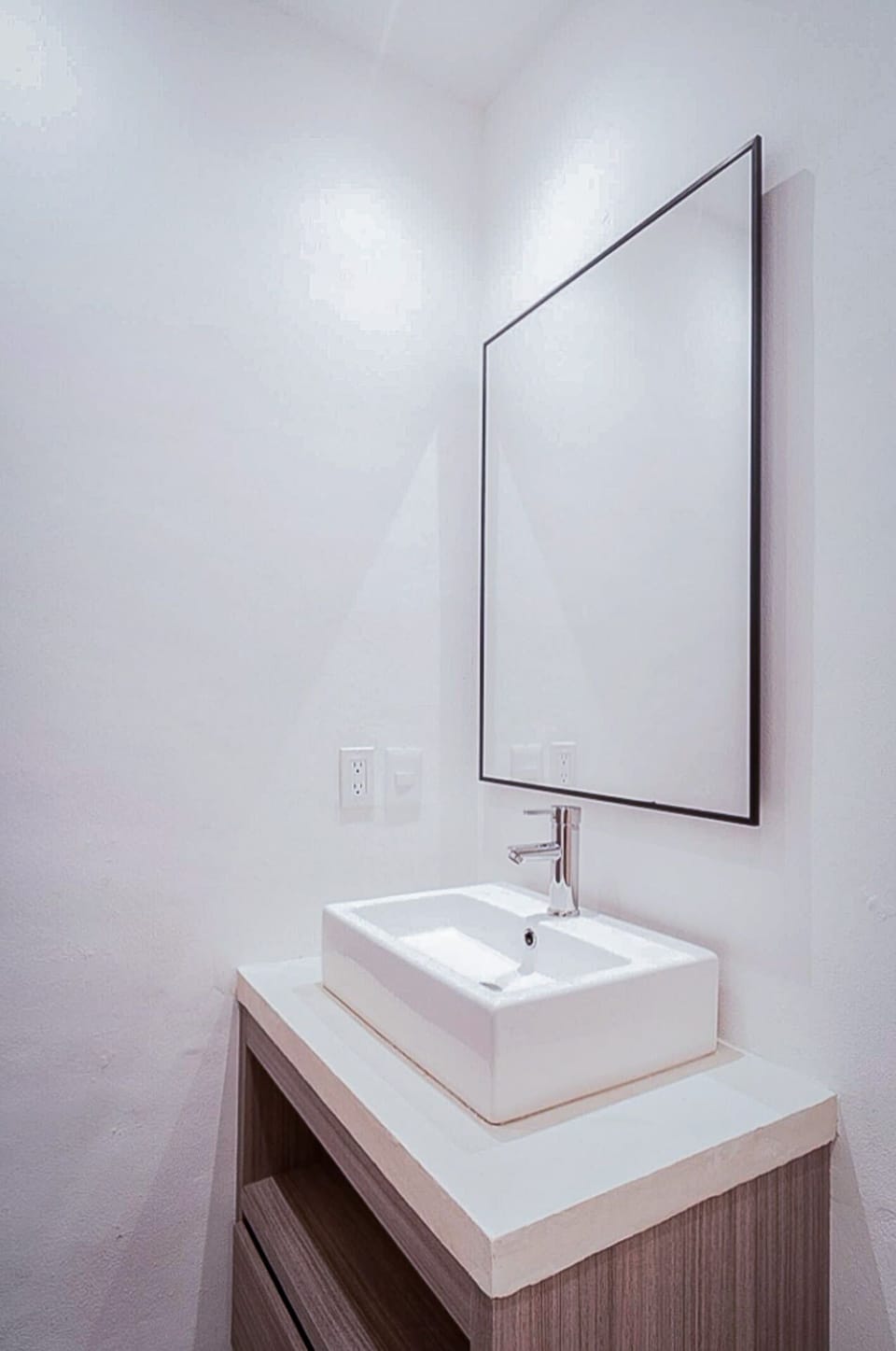 Modern bathroom with a mirror and a sink - stay refreshed and prepared in Playa del Carmen.