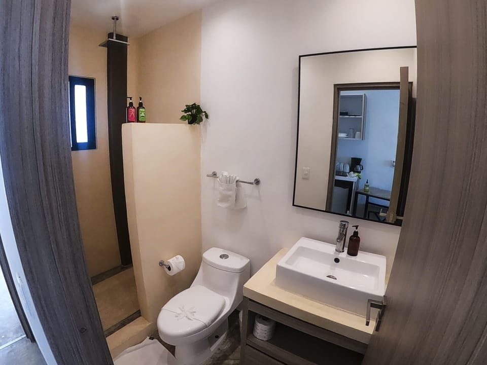 Convenient bathroom with a toilet and sink - experience comfort and privacy in Playa del Carmen.