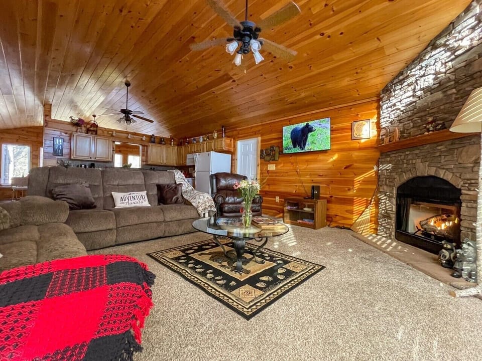 Living room — vaulted pine ceilings and a stone gas fireplace to gather around