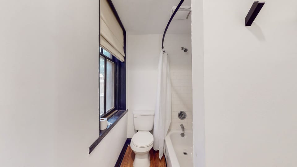 Full Bathroom 1: While the bathroom space is compact, it's got all you need - a toilet and a shower area with a tub.