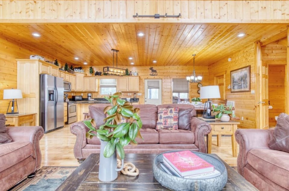 Sink into plush leather seating surrounded by warm wood walls and soaring ceilings in your mountain retreat's open living space.