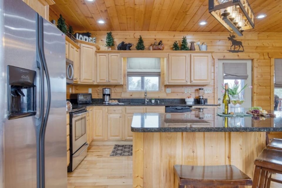 Gather around this spacious mountain kitchen where warm wood meets modern convenience for your perfect cooking retreat.