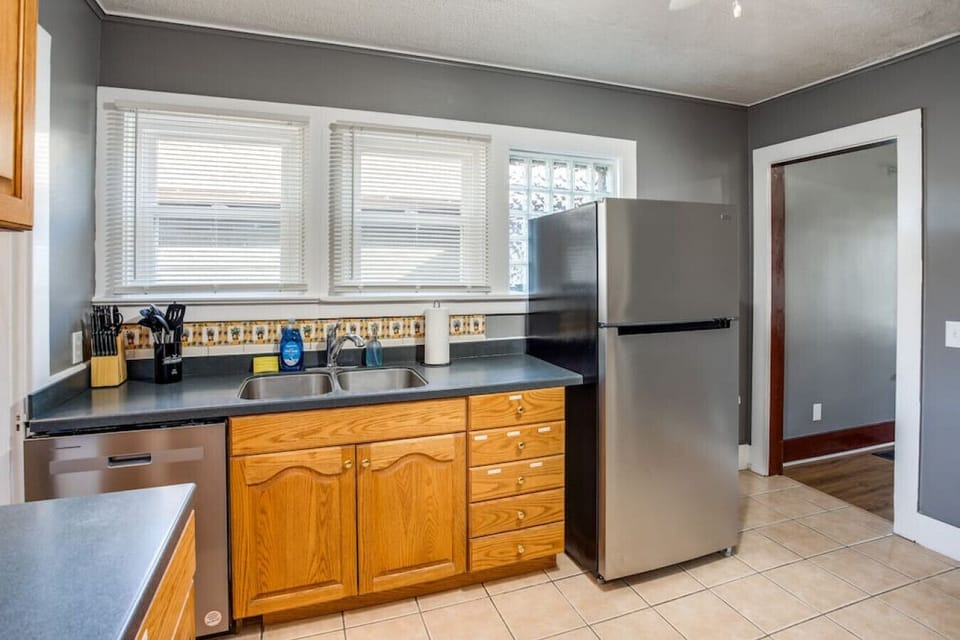 Modern kitchen in Rochester with wood cabinets, patterned backsplash & stainless appliances—stylish retreat blending warmth and function.