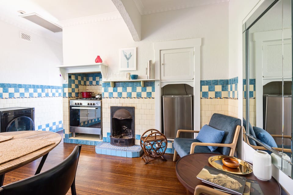 A cosy kitchen area, with a large oven and two beautiful armchairs, dining table