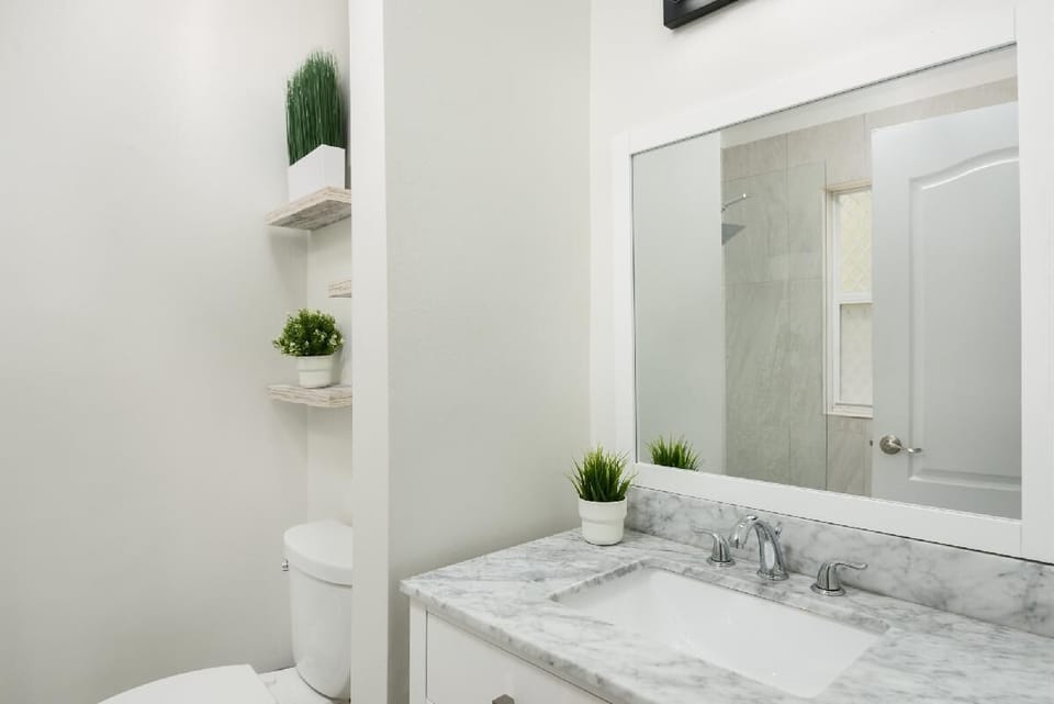 Master Ensuite with large tiled shower, kohler fixtures, marble countertop.