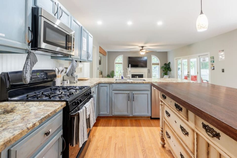 Fully equipped kitchen featuring stainless steel appliances, large island workspace, and open flow to the living area perfect for family cooking.