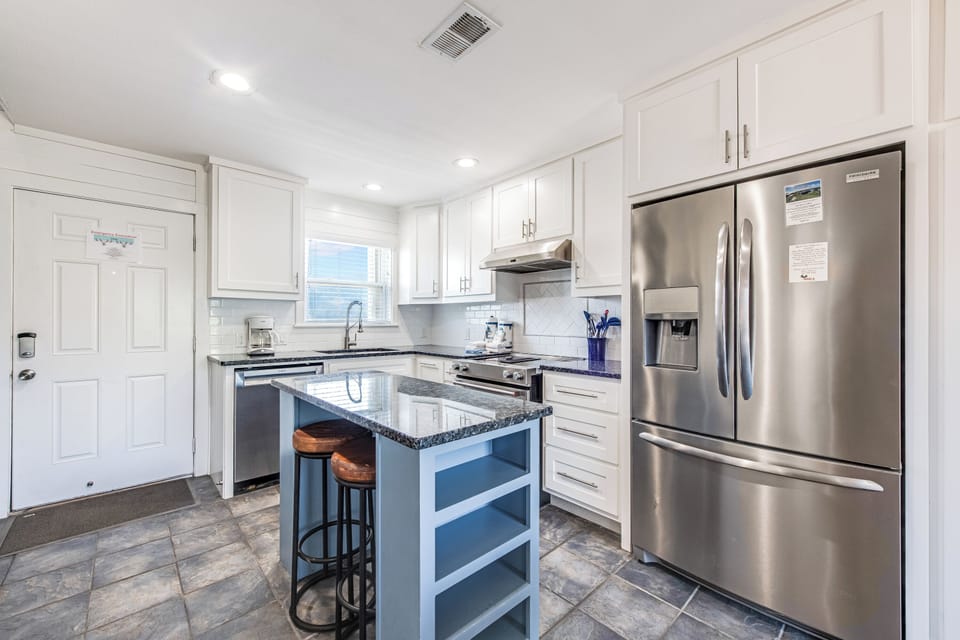 Enjoy preparing meals in your modern kitchen featuring granite counters, stainless appliances, and a convenient breakfast bar for morning coffee.
