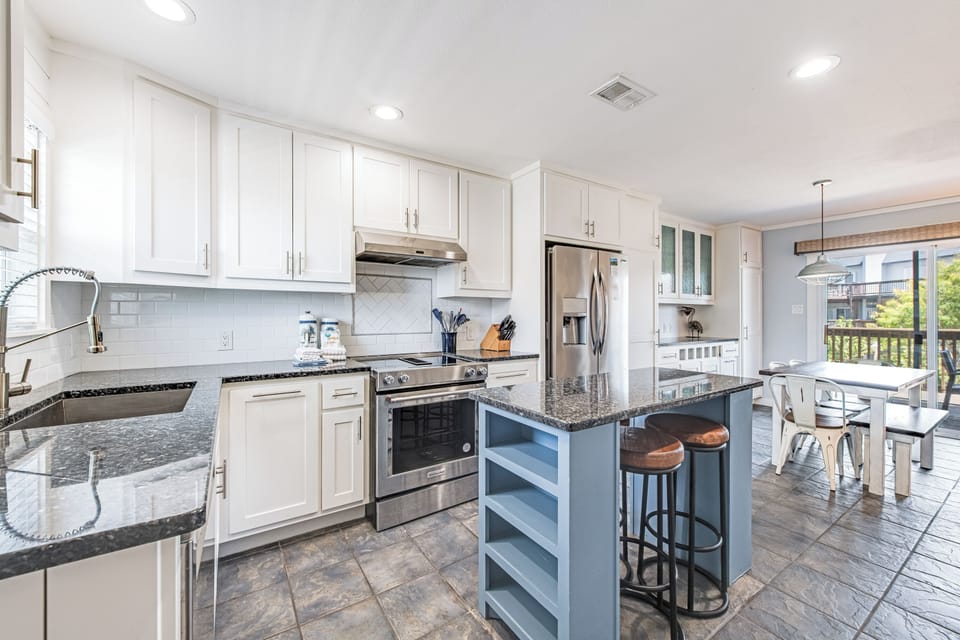Your gourmet kitchen awaits with granite counters, stainless steel appliances, and a charming breakfast island perfect for morning coffee.