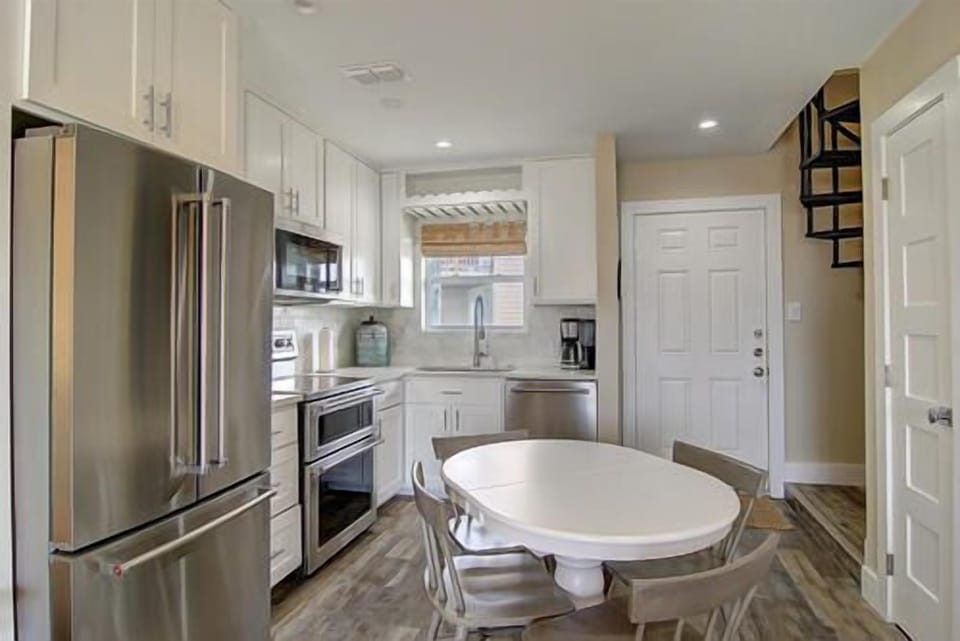 Your modern kitchen awaits with stainless appliances, white cabinets, and bright dining space perfect for morning coffee or family meals.