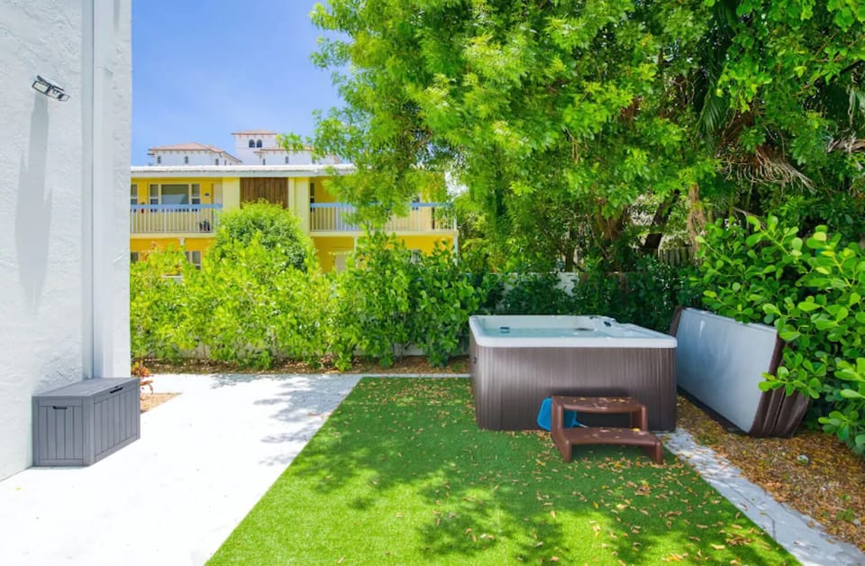 Private hot tub surrounded by greenery for post‑beach relaxation