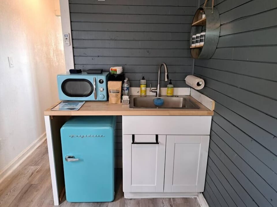 Kitchenette with microwave, mini-fridge, and custom coffee.