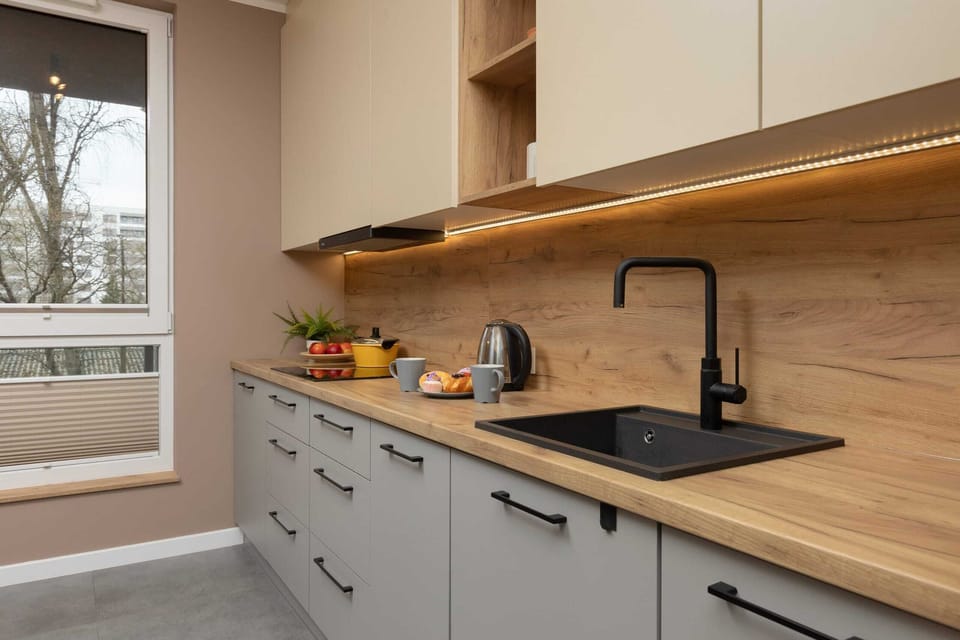 A stylish kitchen with wooden countertops, modern appliances, and a clean design.
