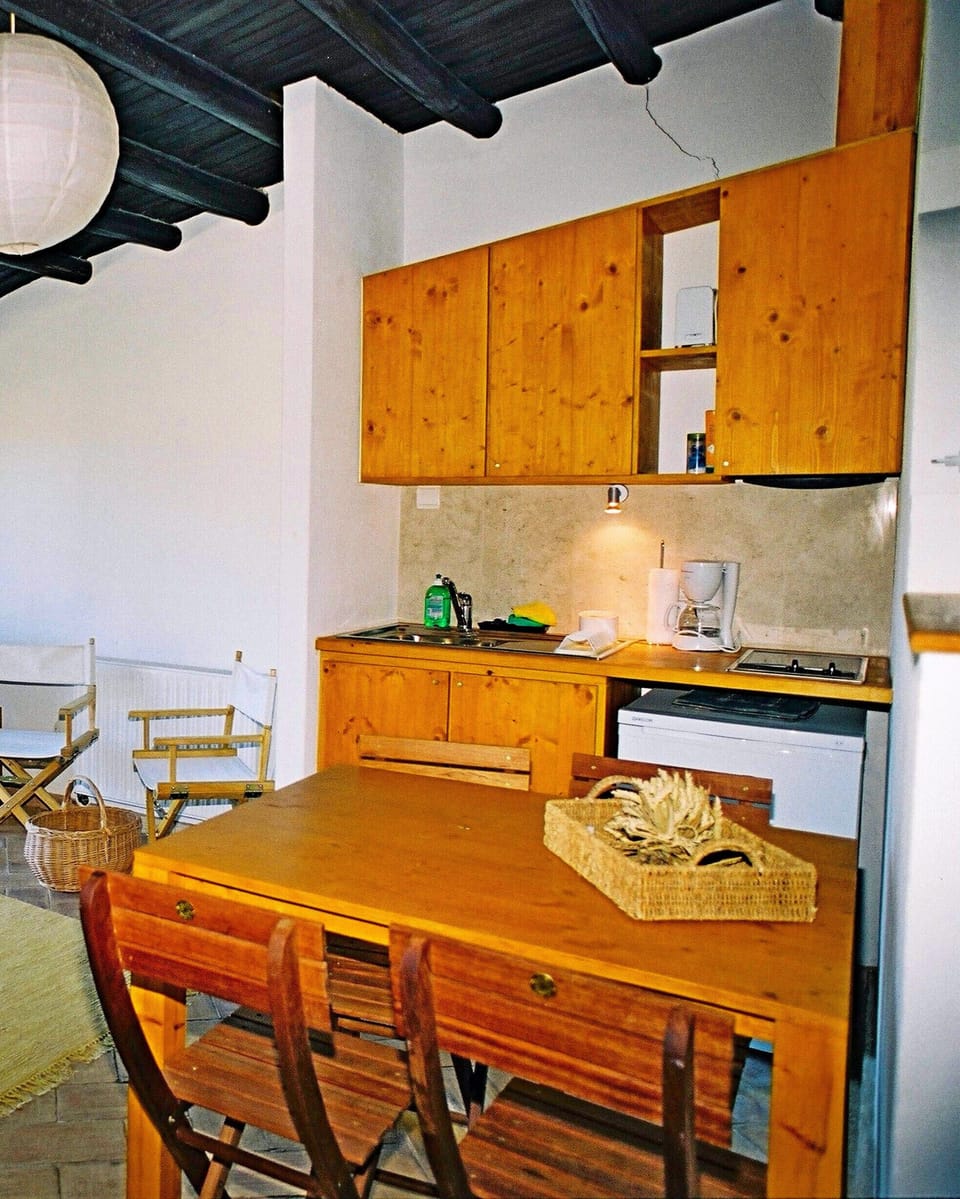 Casa dos Sonhos: A small wooden kitchenette offers all the amenities for a successful meal. Refrigerator and electric cooker as well as sink, coffee maker and toaster are available. A small dining table for 4 people completes the kitchen area.