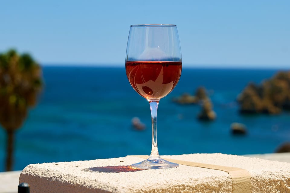 Glass of rosé with a view of Praia Dona Ana Bay