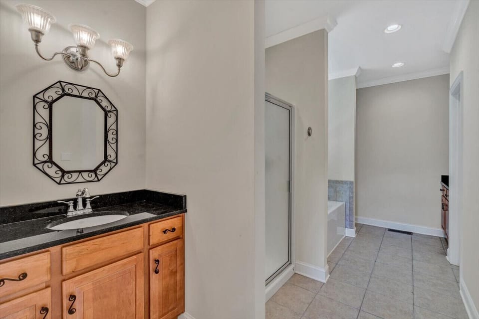 Elegant primary bedroom with ample space and direct access to a beautifully designed bathroom.