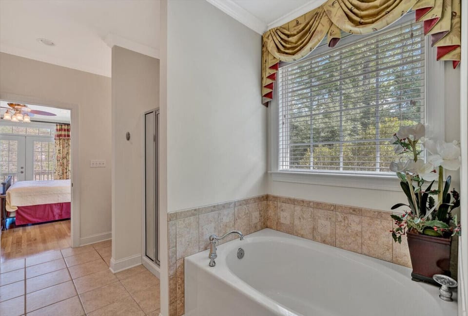 Elegant primary bedroom with ample space and direct access to a beautifully designed bathroom.