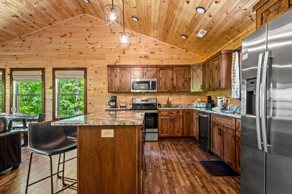 Kitchen includes a full-sized refrigerator, microwave, stove, dishwasher, appliances, cooking pots and pans and utensils.