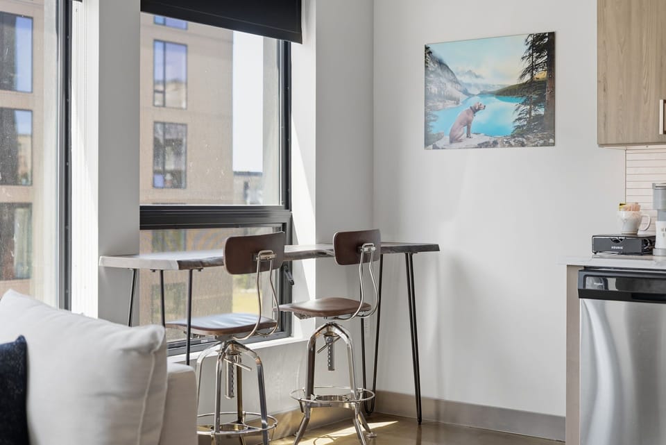 This stylish city apartment offers a bright dining nook where you can enjoy morning coffee with street views, plus a sleek kitchenette ready for easy meal prep.
