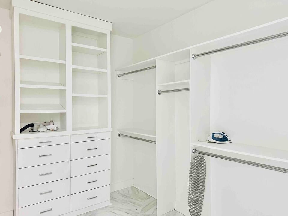 The spacious walk-in closet has plenty of storage for your clothing and luggage. We didn't forget the iron or ironing board.