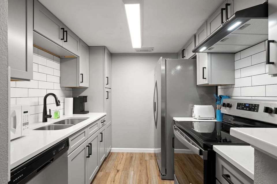 Fully loaded kitchen with new cabinets, quartz counters, tile backsplash and stainless appliances