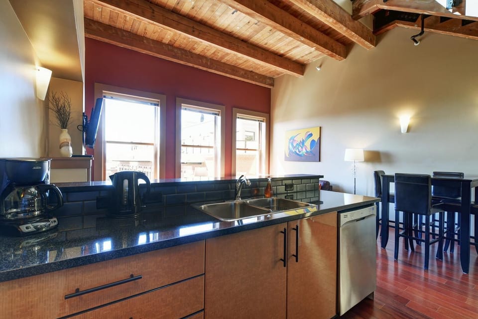 A stunning kitchen with rustic post-and-beam architecture and overhead track lighting.