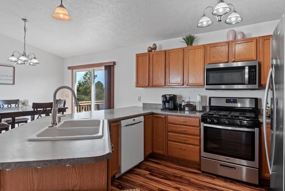 A fully equipped kitchen with cups, bowls, plates, mugs, and silverware is all provided, pots, pans, and cooking utensils.