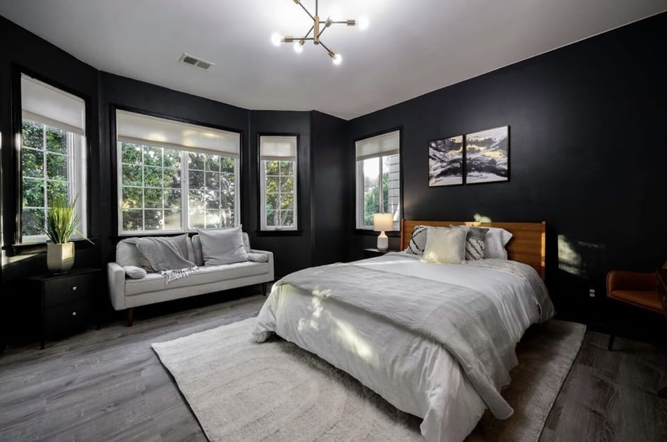 Comfortable queen size bed with large windows and black out curtains.