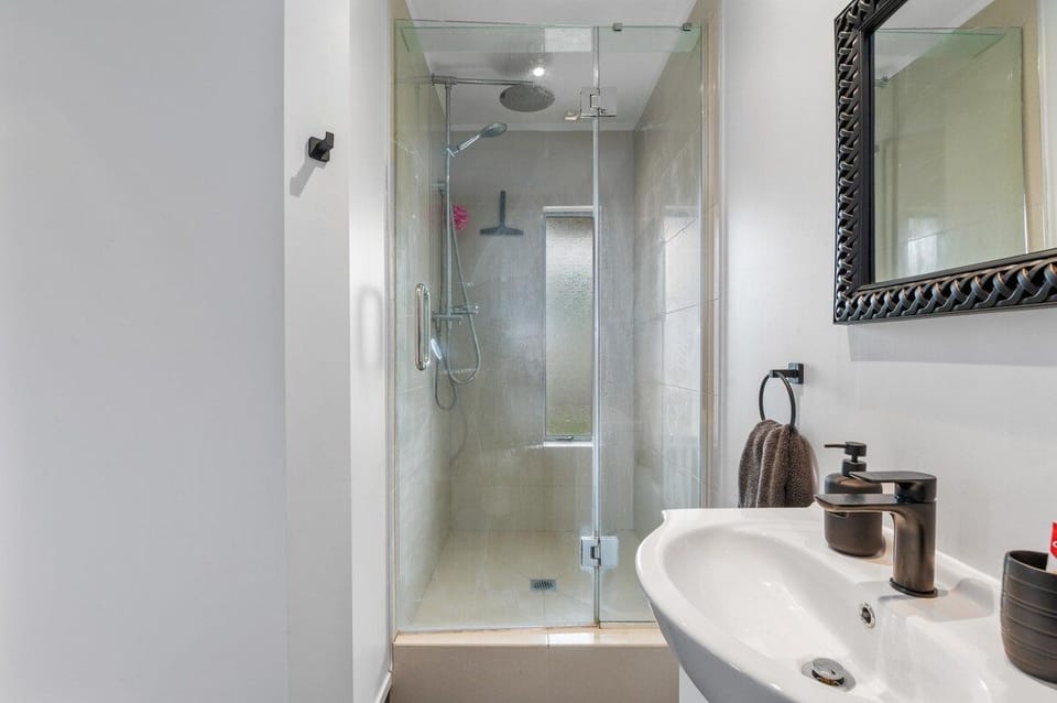 A glass walk-in shower and vanity in the upstairs bathroom.