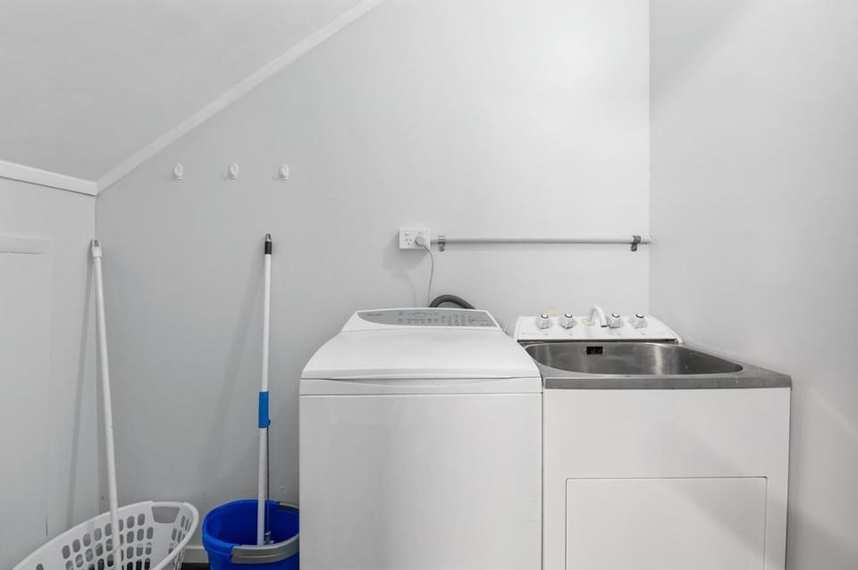 The laundry has a washing machine and tub downstairs.