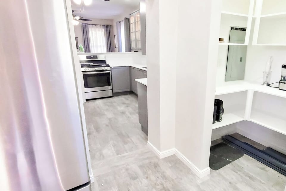 View of the pantry on the right and fridge on the left looking into the kitchen.