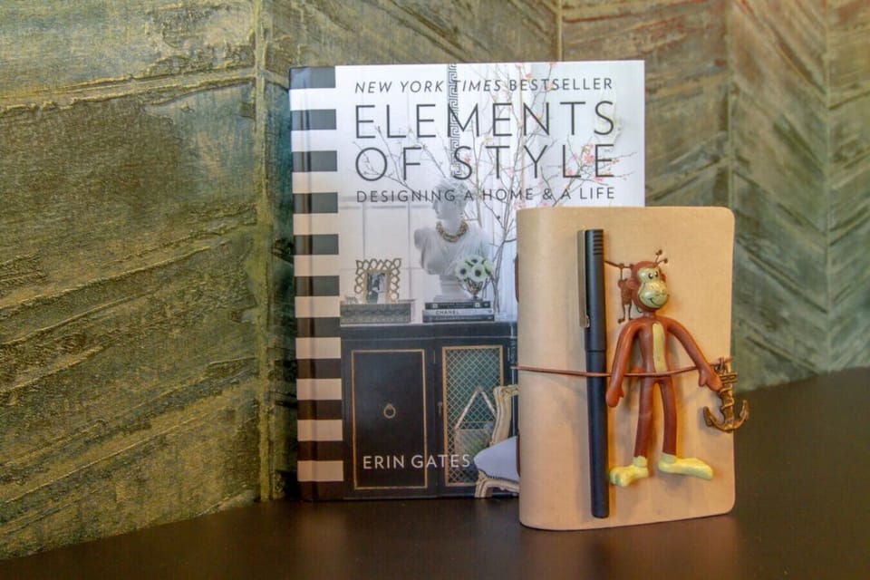 Curated decor shelf with design books, a fox figurine, and a textured stone wall adding personality to the space
