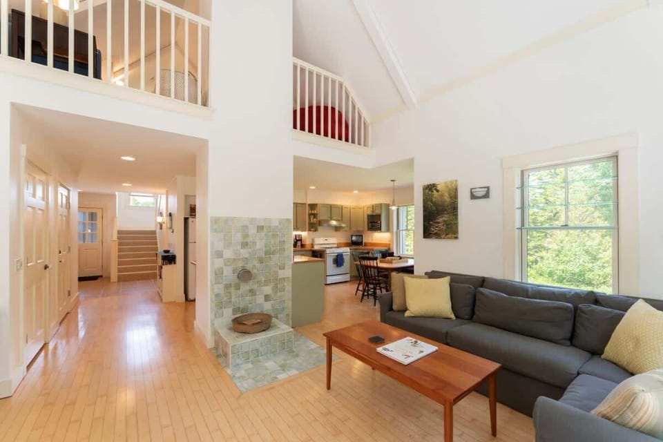 Living room is open to kitchen, dining area and loft above.