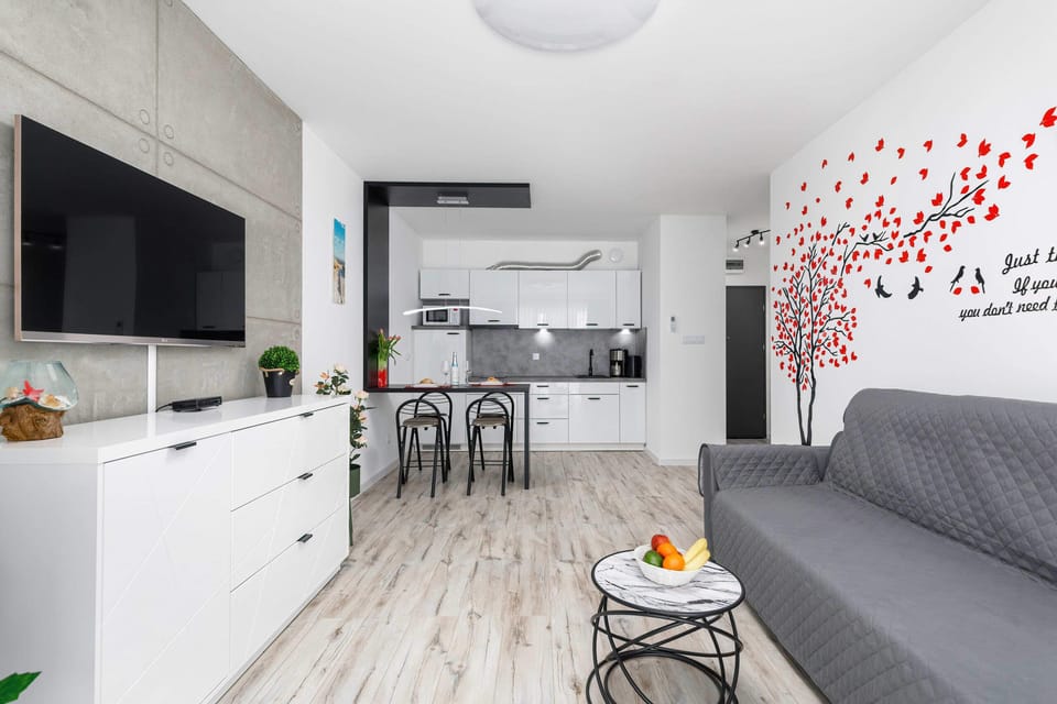Fully equipped kitchen and dining area with sleek design, offering a comfortable space for meals.
