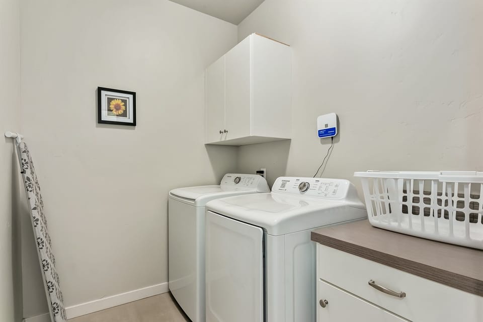Home 1: Spacious laundry room in the home with high quality washer/dryer and sorting counter.