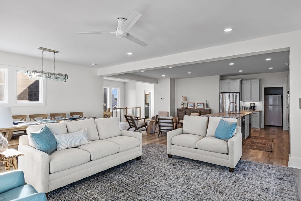 Your spacious open-plan retreat blends living, dining, and kitchen seamlessly. Sink into plush seating with coastal blue accents.