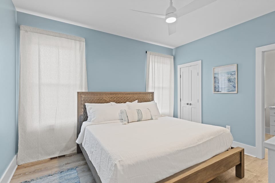 Drift off peacefully in your serene bedroom, where soft blue walls and crisp white linens create the perfect coastal retreat atmosphere.