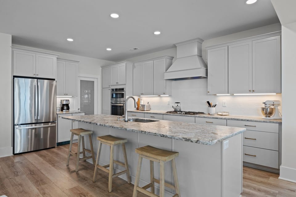 Your spacious kitchen awaits with gleaming granite counters, stainless appliances, and a breakfast bar perfect for morning coffee.