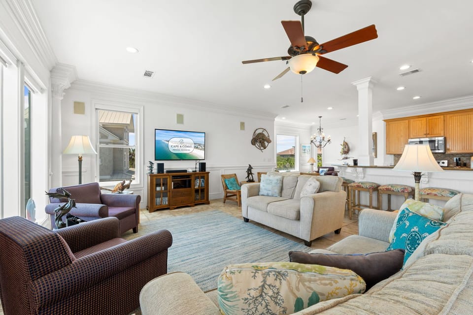 Settle into the bright, spacious living area where plush seating, coastal accents, and natural light create a welcoming retreat for your entire group to gather.