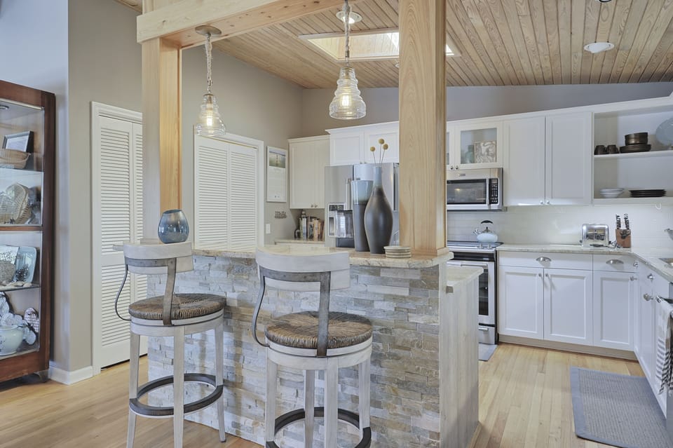 Two rustic bar stools at the kitchen island with view of kitchen in the background.
