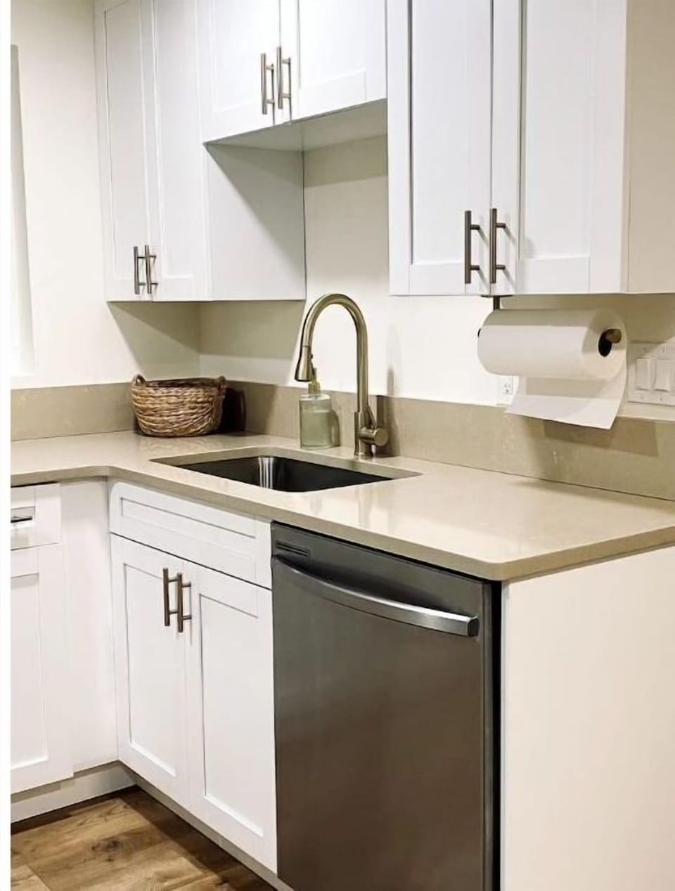 New stainless steel dishwasher. Cleaning items and fire extinguisher under sink.