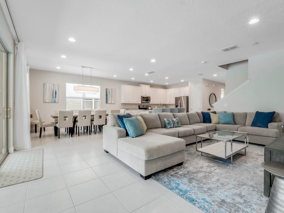 - Spacious open concept living room with sectional seating  
- Vacation rental near Disney with modern kitchen and dining area  
- Perfect family home in Orlando for group gatherings and comfort