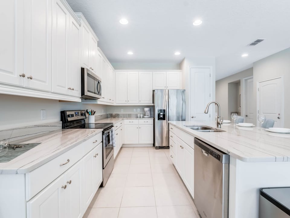 - Modern white kitchen with stainless steel appliances and island  
- Orlando vacation rental with full kitchen for family cooking  
- Spacious home near Disney with updated appliances and style
