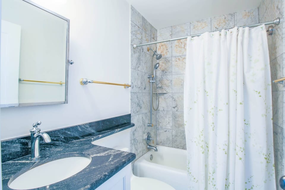 This hallway bathroom with shower/tub combo is shared by the two guest bedrooms.