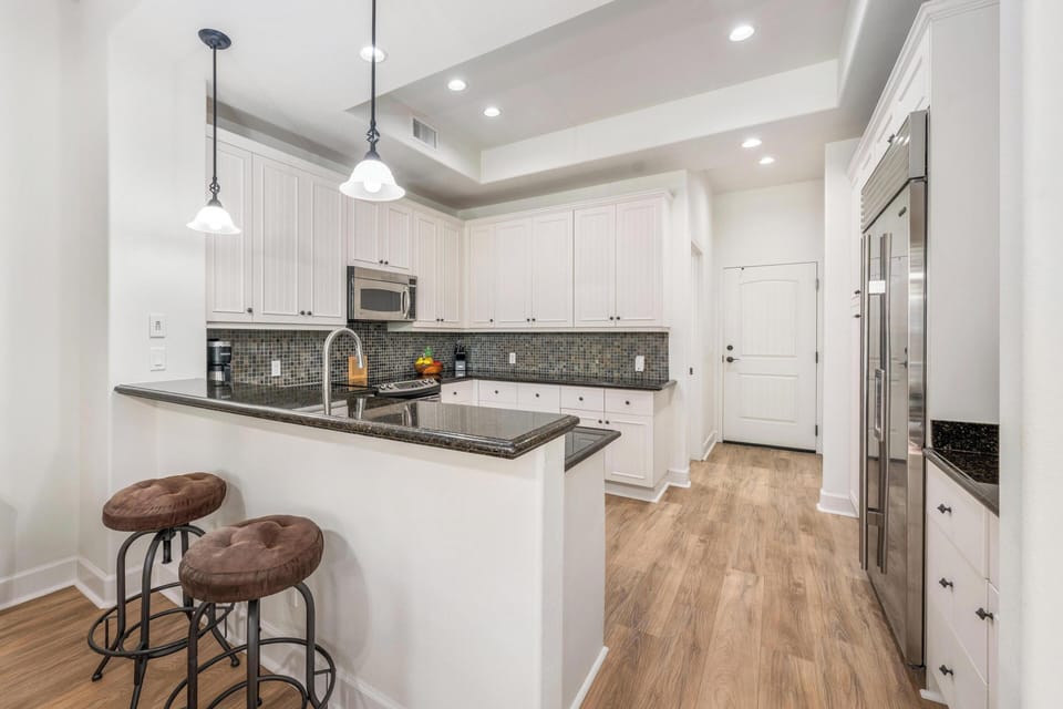 You'll love cooking in this bright, fully-equipped kitchen featuring granite counters, stainless appliances, and a breakfast bar for casual dining.