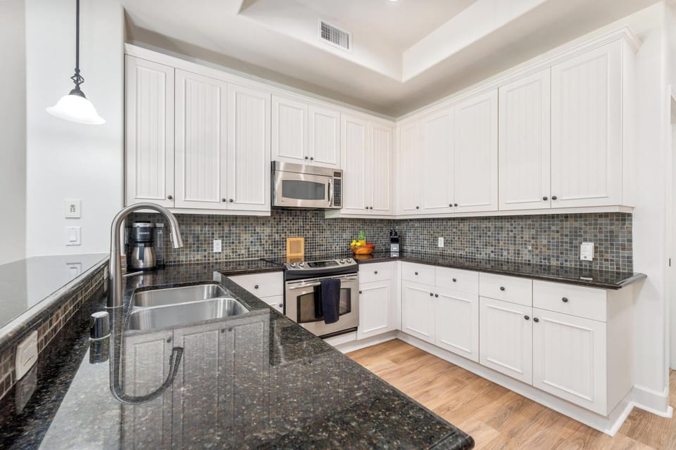 Your fully equipped kitchen awaits with granite counters, stainless appliances, and stylish mosaic backsplash for memorable meal preparation.